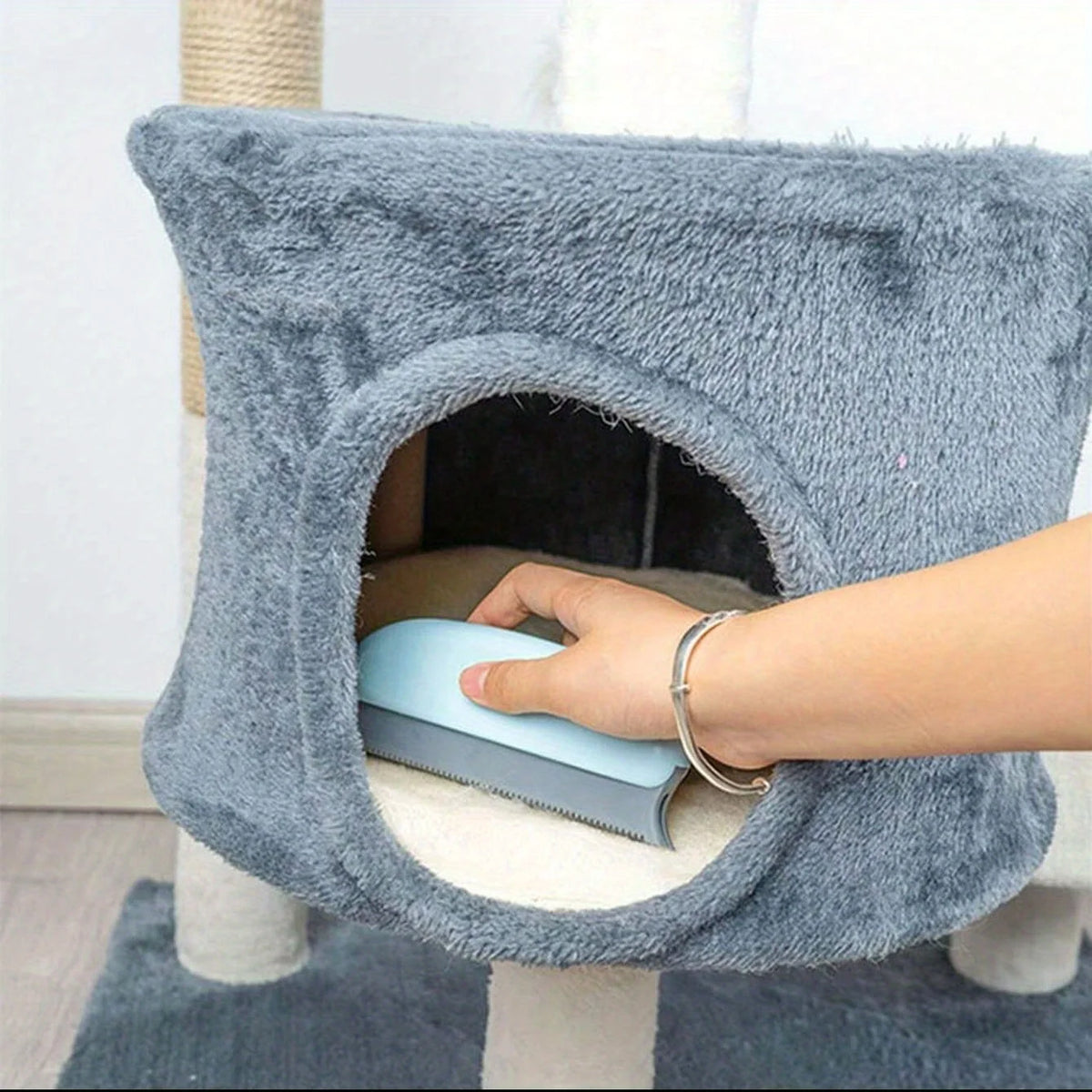 Handheld pet hair scraper brush pulling a pile of dog fur out of a carpet