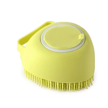 Yellow heart-shaped silicone dog bath brush with a refillable shampoo chamber and hand strap